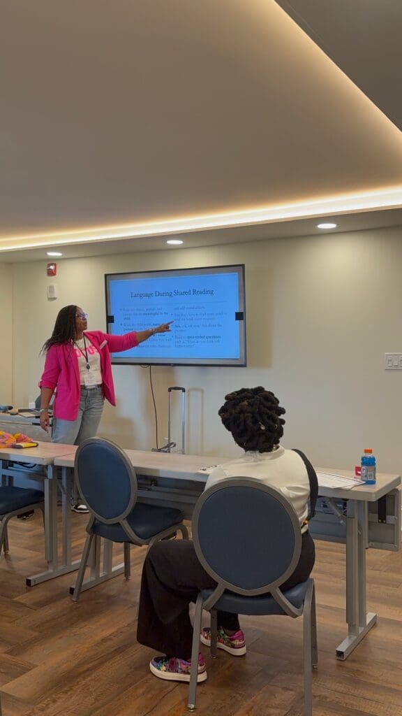 Zoe standing in front of a large screen during a training session